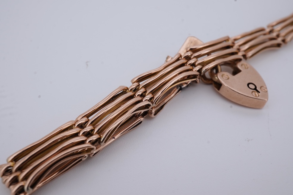 An early 20th century yellow metal gate link bracelet, with heart shaped padlock clasp on safety chain, stamped '9', approx. 18cm, 9.2 grams. Condition - poor